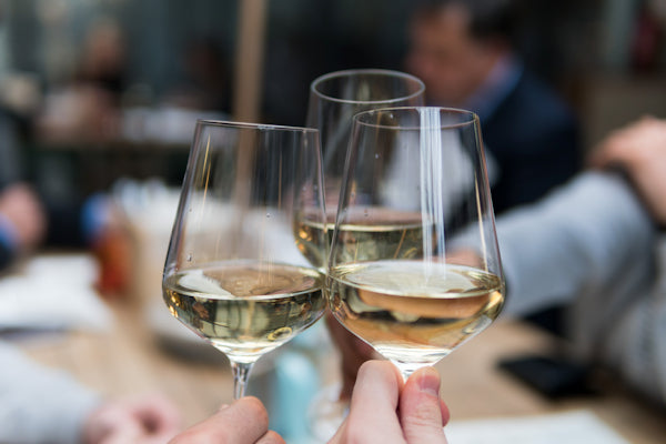 Wine glasses clinking together in celebration.