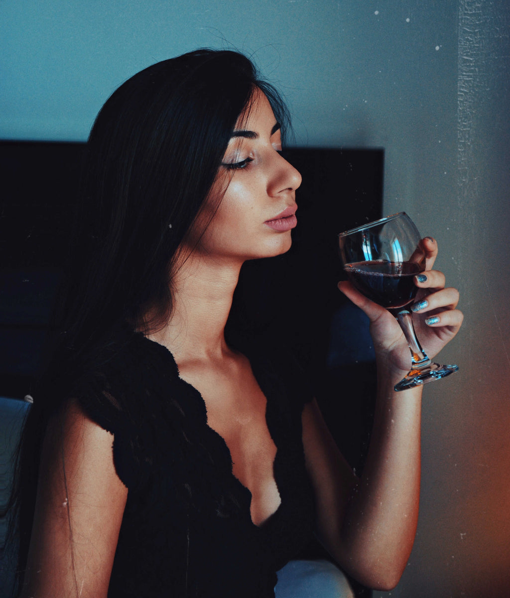 Woman evaluating and observing wine before tasting it.